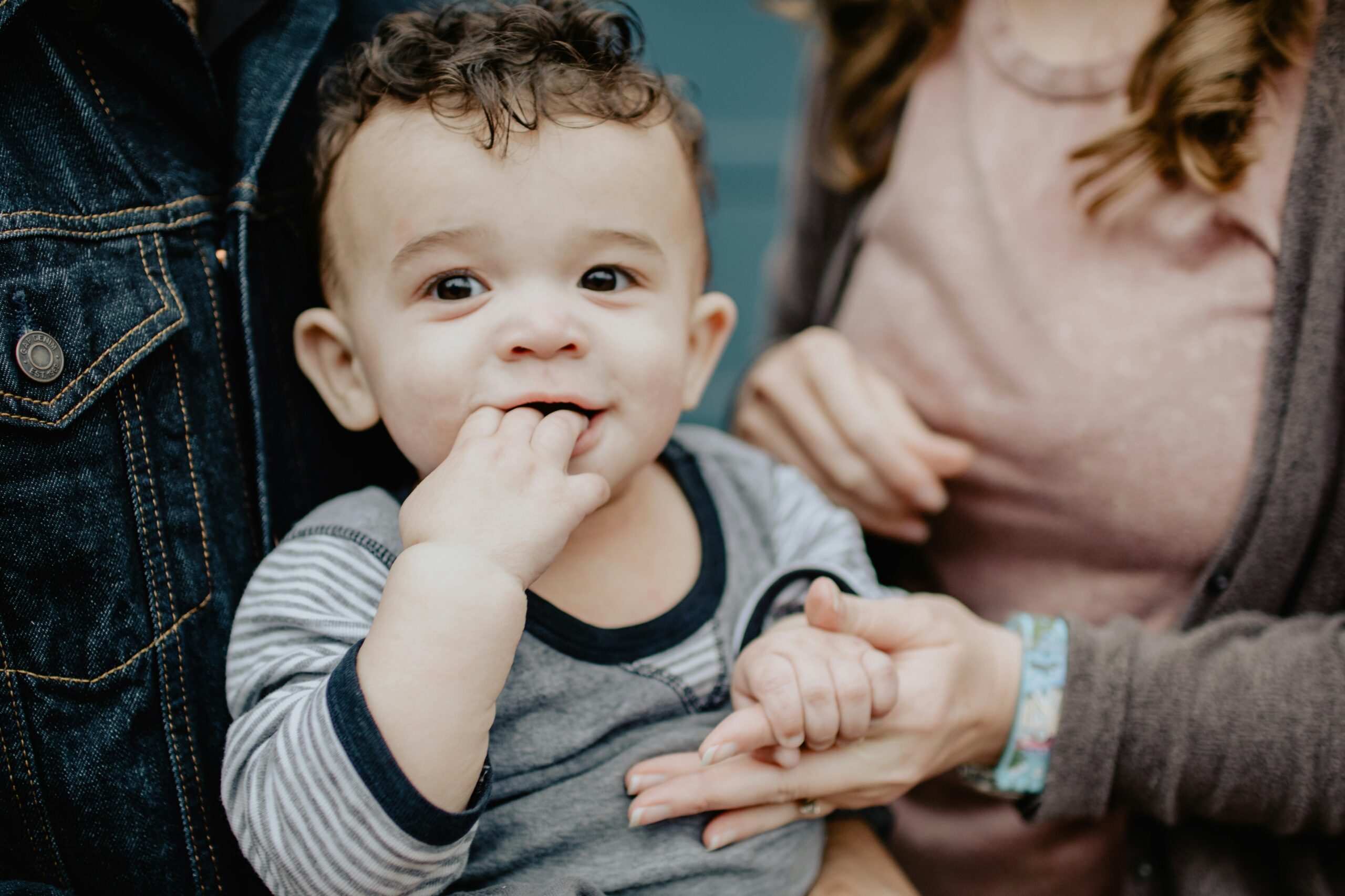 a baby smiling being held by both parents who are practicing mindful parenting