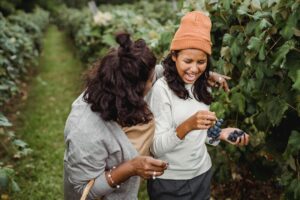 mother and teen daughter smiling in a vineyard field together after bonding as a result of humanistic parenting