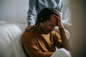 a man looks down as he grapples with understanding grief