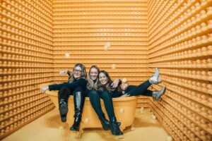 three friends at an art exhibit showing the joy of play as an adult