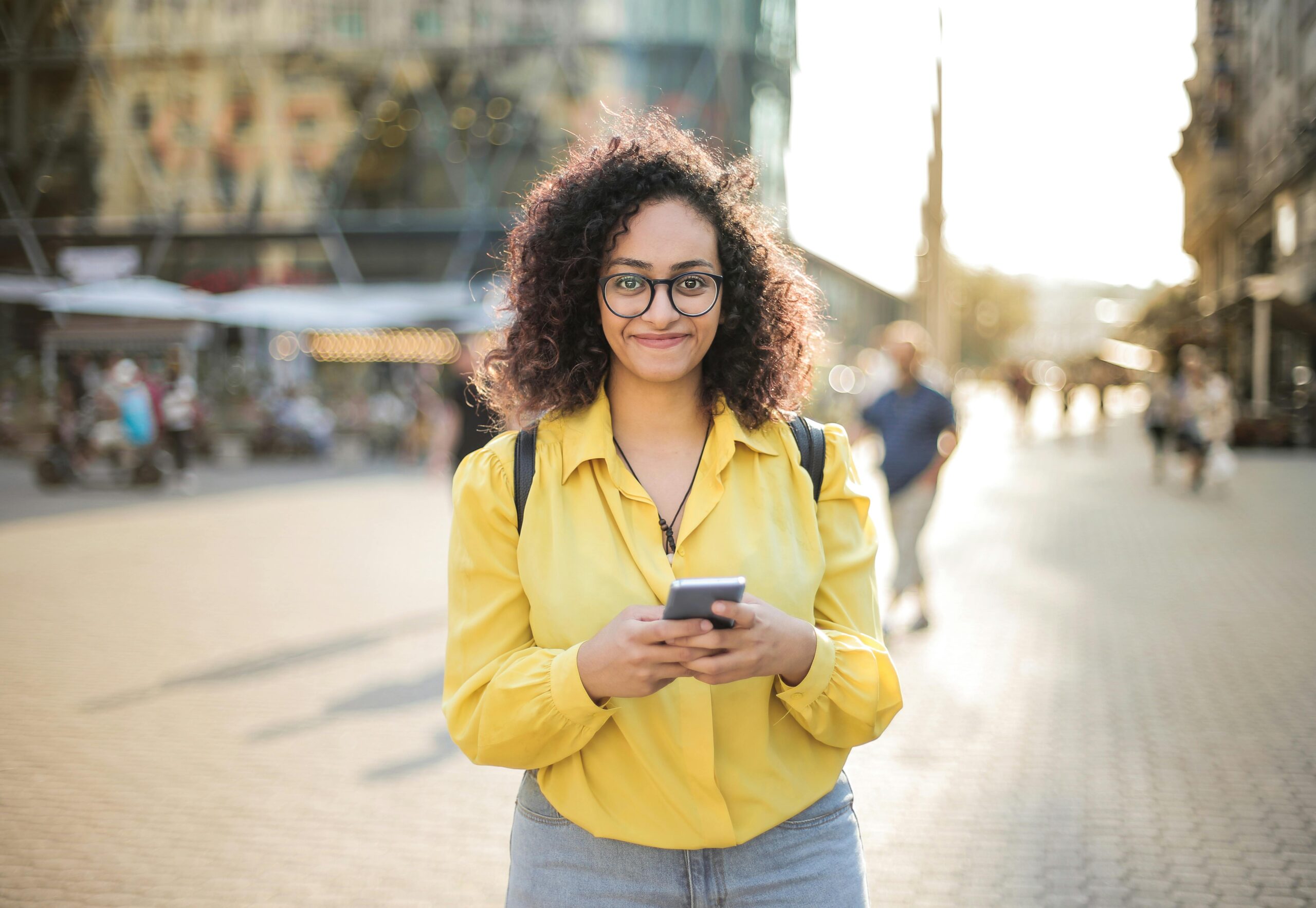 woman smiling holding her phone after overcoming phone addiction in therapy